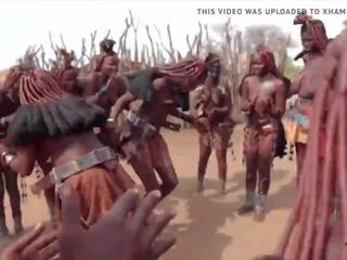 الأفريقي himba نساء رقص و أرجوحة هم ساغي الثدي حول